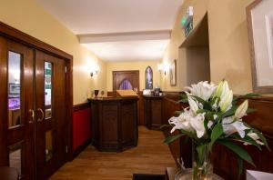 巴拉特奥尔德柯克酒店的一间设有前台和花瓶的房间