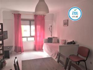 São MarcosApartamento Familiar Lisboa Taguspark的一间卧室配有床和一个带粉红色窗帘的窗户。
