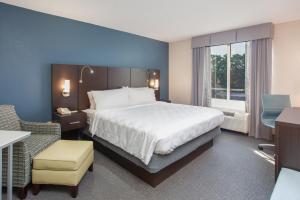 塔拉哈西塔拉哈西会议中心北假日套房酒店的酒店客房带一张大床和一把椅子