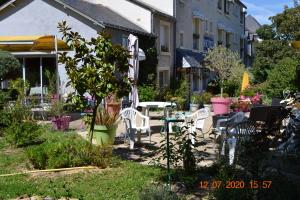 Brissac-Quincé乐卡斯特酒店的花园内带桌椅的庭院