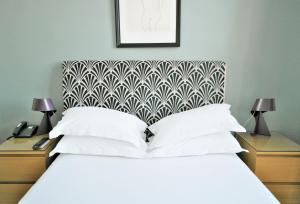 马赛Hotel Belle-Vue Vieux-Port的卧室配有白色的床和带灯的2个床头柜。
