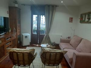 毕尔巴鄂Apartamento El 31 de Bilbao的带沙发和椅子的客厅以及窗户。