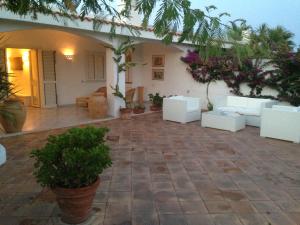 奥斯图尼Villa Masai的房屋内带白色家具和植物的庭院