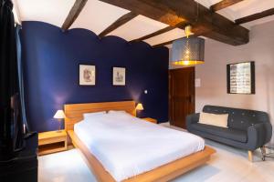 蒙斯金佩蒂特龙旅馆的一间卧室设有一张床和蓝色的墙壁