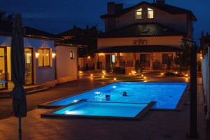 桑日卡Oasis family apartments的两人晚上在游泳池游泳