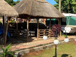 恩德培Lake Victoria Country Home的配有灵气伞和桌子的度假村