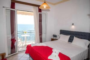 帕拉马Empress Corfu的一间卧室设有一张床和一个海景阳台