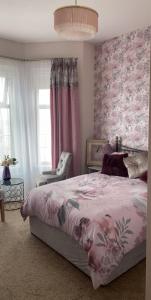 纽卡斯尔Conlyn house的一间卧室配有一张床和粉红色的花卉墙