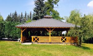 奥斯特罗维茨Willa-Restauracja Victoria的田野上带屋顶的木制凉亭