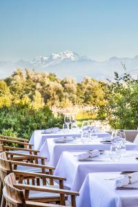 克罗泽特Jiva Hill Resort - Genève的一组配有白色桌布的桌子