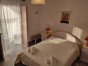 AloproniaPorto Sikinos Hotel的卧室配有白色床和毛巾