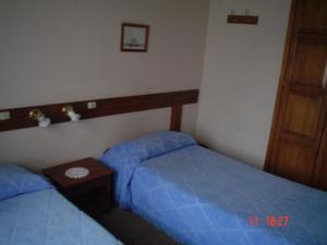 埃斯克尔拉波萨达旅馆的一间卧室设有两张单人床和一张桌子