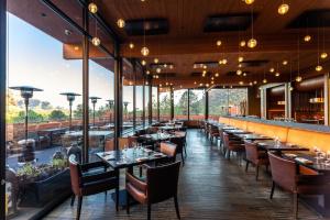塞多纳Enchantment Resort的餐厅设有桌椅和大窗户。