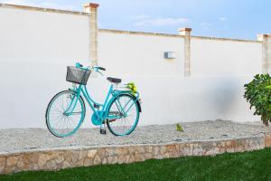 马尔扎梅米I Gufi Bed & Breakfast Marzamemi的一辆停在白色墙壁旁边的蓝色自行车