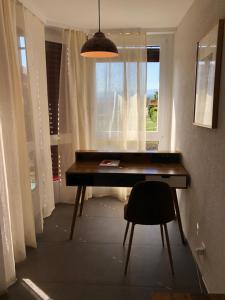 EcublensAmazing Studio In Lausanne Close To Epfl Unil的一张桌子,房间带窗户和椅子