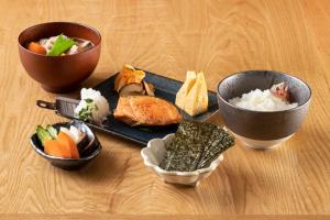 东京Hotel Kazusaya的一张桌子,上面放着两个碗和一盘食物