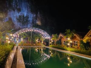 宁平Tam Coc Valley Bungalow的夜间带游泳池的度假村