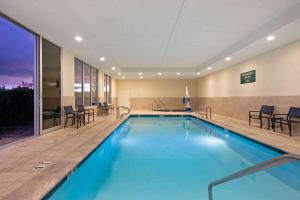 摩根山摩根山圣何塞南拉昆塔套房酒店的游泳池位于酒店客房内,配有椅子和桌子