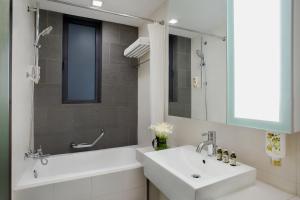 苏州苏州馨乐庭星海公寓酒店的一间带水槽、浴缸和镜子的浴室