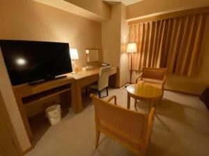 SabaeSabae City Hotel的酒店客房配有书桌和电视。