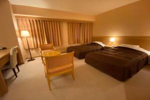 SabaeSabae City Hotel的酒店客房配有两张床和一张书桌