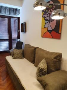 诺瓦利娅Apartmani Nada的客厅的沙发,墙上有绘画作品