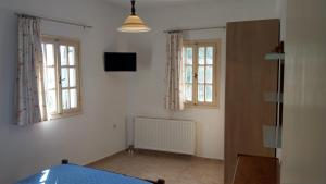 锡基诺斯岛Chora Place的客房设有床、两扇窗户和电视。