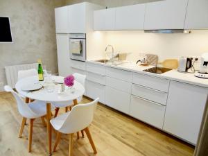 ZimmerbachLa Couette Enchantée - Parking - Zimmerbach的厨房配有白色橱柜和白色的桌椅