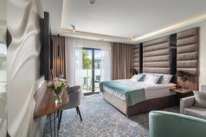 索波特Love Sopot Residence的酒店客房配有一张床、一张书桌和一张沙发。