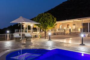 维勒克哈德哈Promitheas Villa, Sea Side Resort, By ThinkVilla的一座游泳池,在晚上在建筑物前