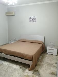 泰尔米尼伊梅雷塞Case marino的白色房间的一个床位,配有两个床头柜和两张桌子