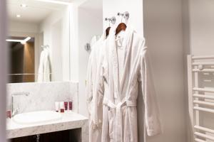 敦刻尔克Hôtel Merveilleux Côté Mer的浴室设有挂在架子上的白色长袍
