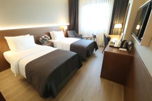 伯萨布尔萨市中心假日酒店的酒店客房设有两张床和窗户。