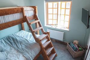 ManstonCheesemans Farm Stables的一间卧室配有带梯子的双层床