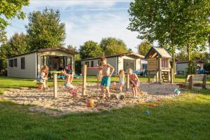 LuttenbergVakantiepark de Luttenberg的一群儿童在院子里的沙子里玩耍