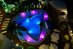 阳光海滩Sweet Homes 6 Apartments的享有带紫色灯的游泳池的顶部景致