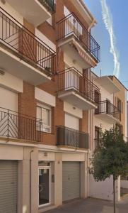 卡隆赫Apartamento Can CALET con PARKING en Sant Antoni de Calonge的公寓大楼设有阳台和2扇车库门