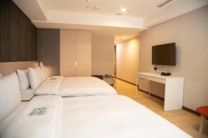 台北HATAGO+ THE ALLEY的酒店客房设有两张床和电视。