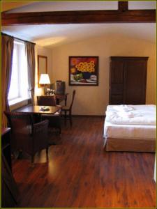 贝格施特拉瑟黑彭海姆巴丁别墅酒店的一间卧室配有一张床、一张桌子和一张桌子