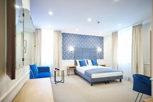波兹南Apartamenty Klasztorna 25的一间卧室配有一张床和一张蓝色椅子
