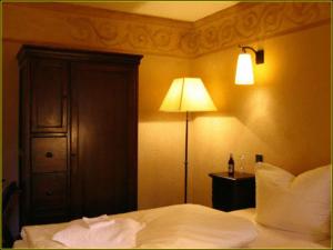 贝格施特拉瑟黑彭海姆巴丁别墅酒店的一间卧室配有一张床,旁边配有一盏灯