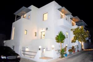 纳克索乔拉Naxos Enjoy Apartments的一座白色的大建筑,灯火通明