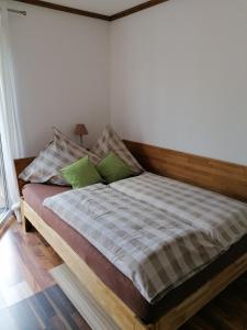 WellingGemütlich wohnen in Welling的一间卧室配有一张带两个绿色枕头的床