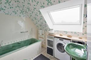 迪纳尔L'Opalin by Cocoonr - en plein cœur de Dinard的洗衣房配有绿色水槽和洗衣机