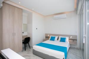 拉纳卡Les Palmiers Sunorama Beach Apartments的配有一张床和一张书桌的酒店客房