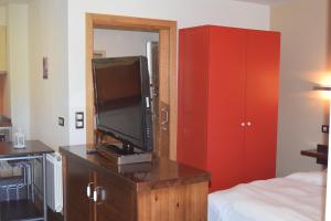 贝加德奥阿尔博拉达德尔奥酒店的卧室配有带电视的梳妆台和床