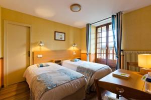 Chambon-sur-Dolore拉格莱德酒店的酒店客房设有两张床和一张桌子。