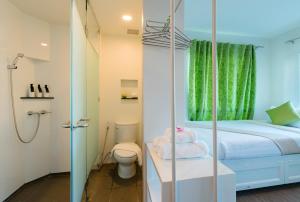 洛坤府查达@洛酒店的一间带一张床、淋浴和卫生间的浴室