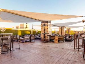 马德里马德里市中心诺富特酒店的露台设有天篷下的桌椅