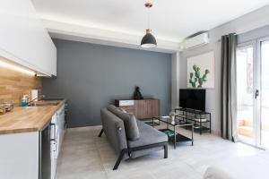 雅典Omnia Pagrati Apartments的厨房以及带椅子和电视的客厅。